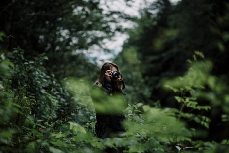 Image of woman taking photos in forest